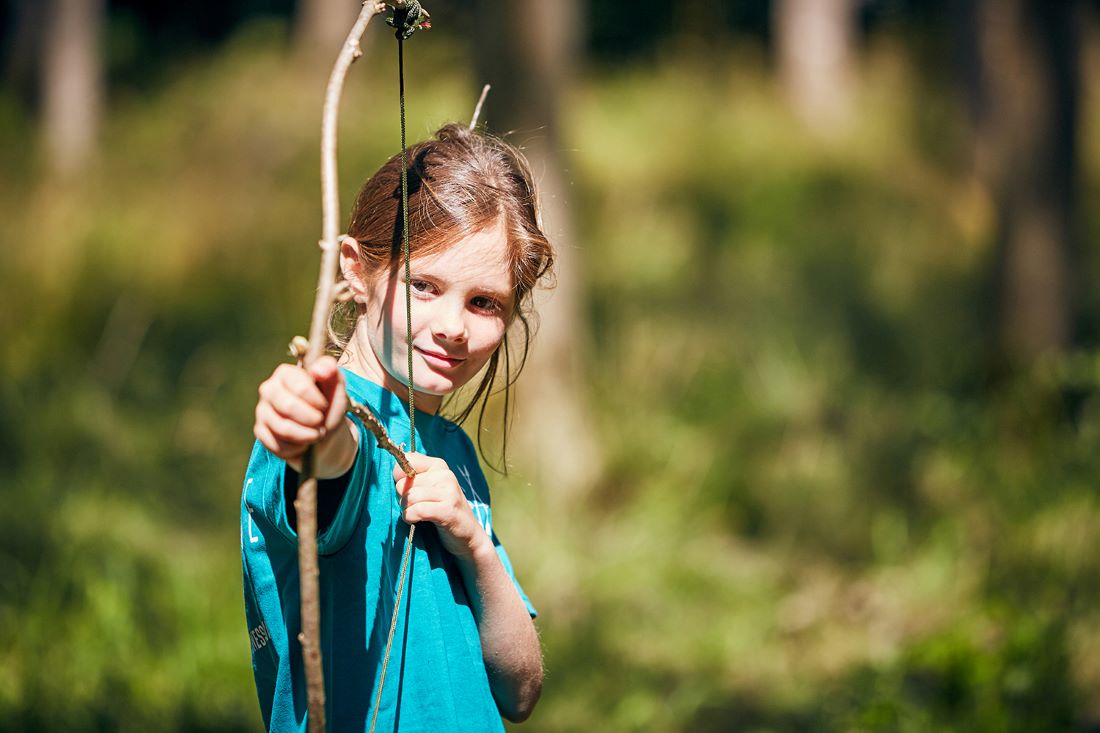 child with makeshift bow and arrow