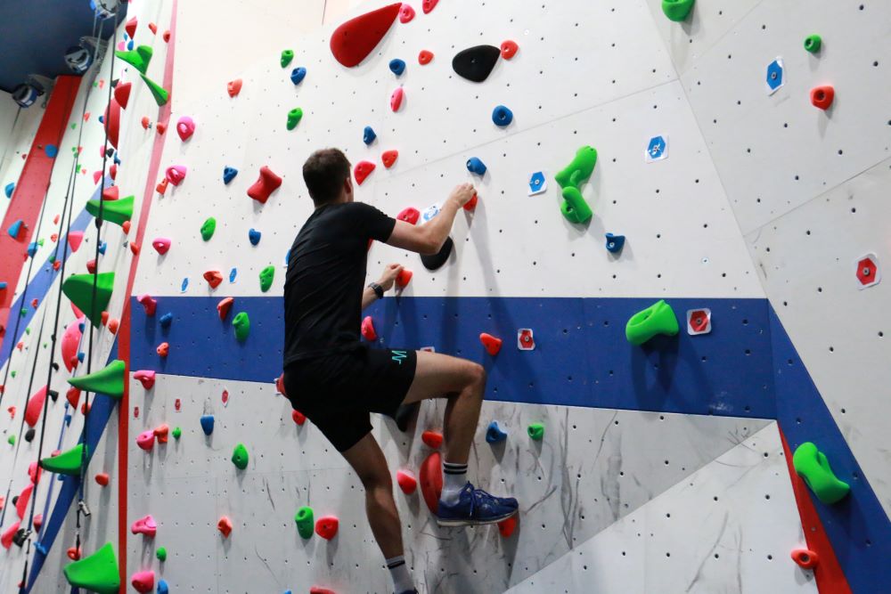 Man climbing up climbing wall