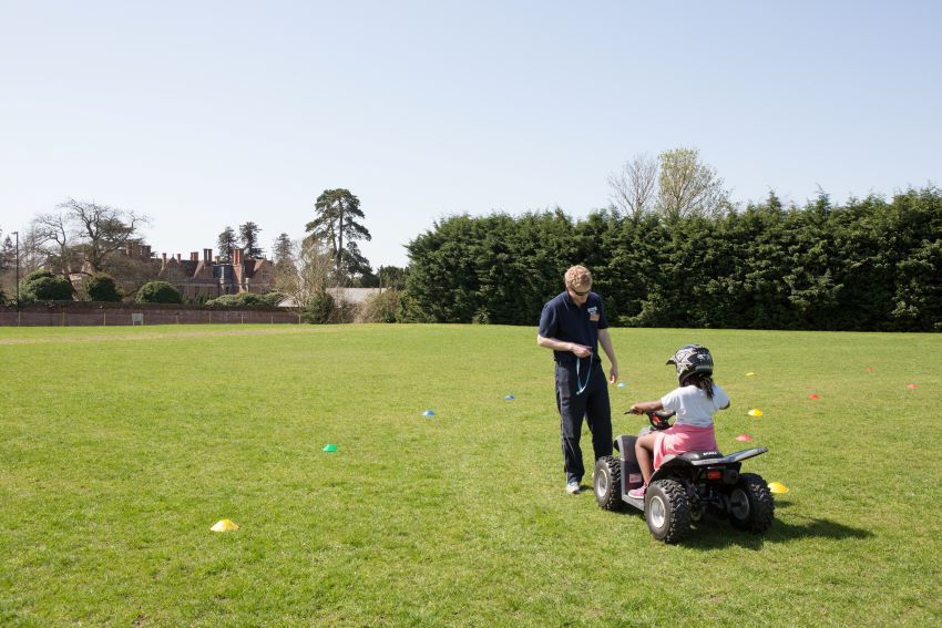 child on quad with staff